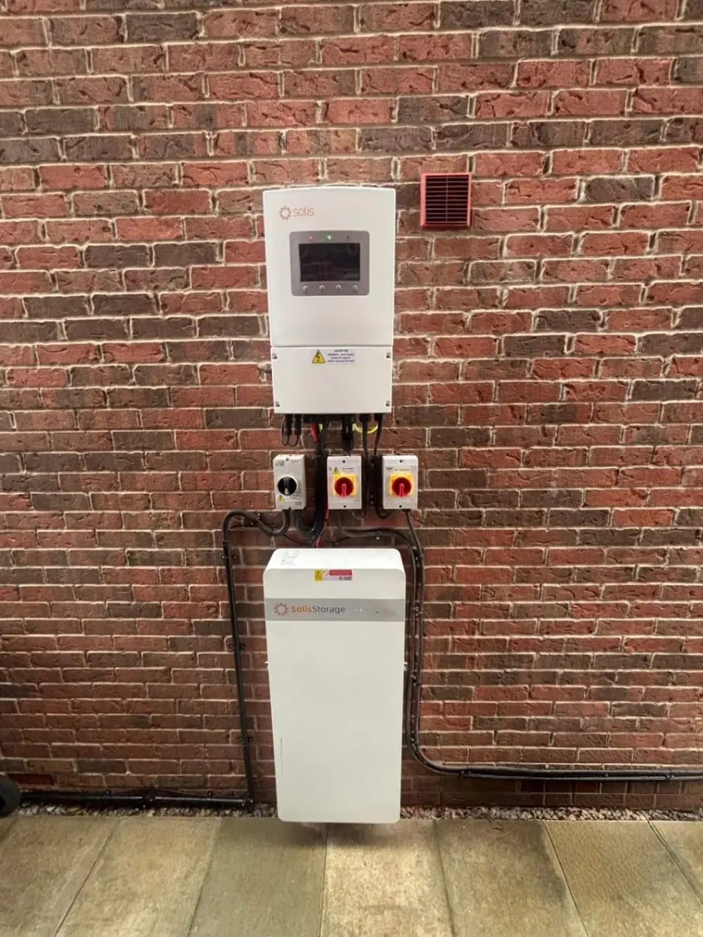 Solis hybrid inverter and Solis battery storage installed on a brick wall